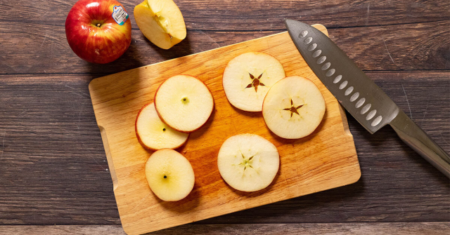 Apple slices on a cutting
board, each with a hole in the middle from the seed capsule in the
center of the core, in the shape of a five-pointed star.