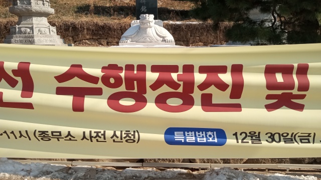 A yellow banner with Korean text in
large red Korean script on top and smaller text below.  If you look
just at the bottom half of the most prominent Korean word, it looks
like it says TOOL.  But this is coincidence, because the Korean script
just happens to contain shapes that are the same as the letters of TOOL.