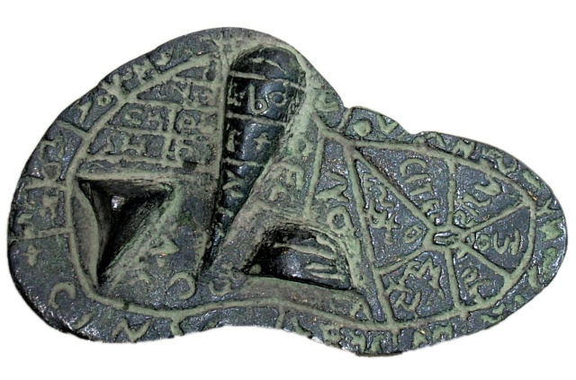 A bronze artifact in the
shape of a sheep's liver, with lobes visible. The surface is mostly
flat, but with three geometric protrusions representing anatomic
features of the liver. Grooves divide the surface of the artifact into
labeled regions.  The labels are incised into the bronze, and are in
Etruscan script.