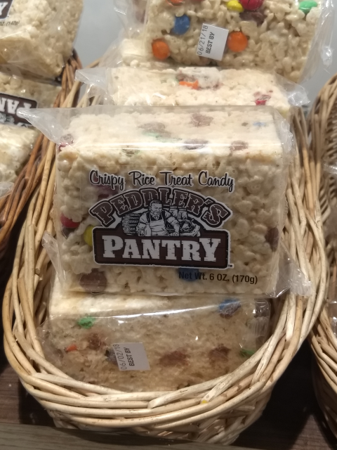 A puffed
rice confection with small embedded M&M-style candies, wrapped in
clear cellophane with the description 'Crispy Rice Treat Candy' and,
in larger letters, "Peddler's Pantry"