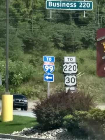 Directional
signs by the side of a road, offering directions to U.S. Routes 220
and 30, and to Interstate 99.