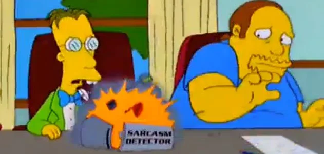 Screencap of a
Simpsons episode in which the Comic Book Guy overloads Professor
Frink's Sarcasm Detector. The Comic Book Guy is overweight and
bearded, with a receding hairline.  Professor Frink has thick
bottle-bottom glasses, buck teeth, and a bow tie.  In front of Frink, a
boxlike tabletop device labeled “SARCASM DETECTOR” is exploding.