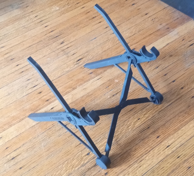 black laptop stand on
the floor.  It is three X'es, two parallel and about twelve inches
apart, with arms to hold up the laptop, and one in the front to hold
the other two together